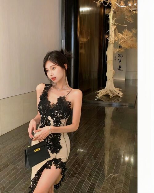 Woman wearing a black lace aesthetic sling dress with a beige lining, elegant evening wear.