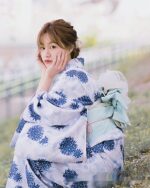 A woman wearing a blue japanese yukata with floral pattern, summer aesthetic kimono.