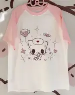 Pink neko nurse t-shirt with a cute cartoon cat character and medical symbols.