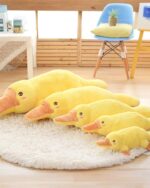 Multiple kawaii platypus plushies in yellow, soft plush material on a rug.