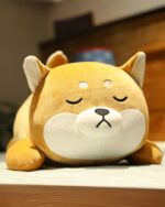 Close-up of Fred, a Shiba and husky plushie, lying down with a peaceful expression.