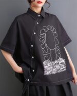 Black retro aesthetic shirt with floral and abstract graphic details, short sleeves.