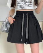 Black elastic Korean aesthetic shorts with drawstring detail. Casual summer style.
