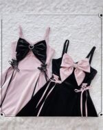 Two kawaii goth dresses: a pink velvet dress and a black velvet dress, each with a large bow and lace detailing.