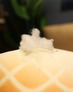 Close-up of a Kawaii melonwan plushie with fluffy stuffing.