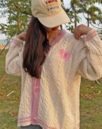 Cream-colored kawaii embroidered sweater with pink accents and a heart design. A stylish cardigan.