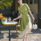 Woman wearing a green french vintage dress with a beige skirt, outdoors.