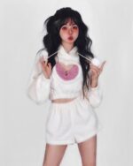 Model wearing a white kawaii fluffy pajamas set with a heart design.