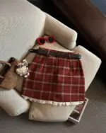 Red plaid mini skirt, a preppy aesthetic skirt, displayed on a sofa.