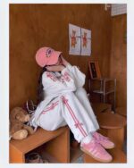 Young woman wearing a korean aesthetic set, including a sports sweater and Adidas sneakers.