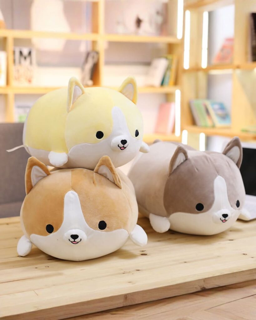 Stack of kawaii corgi plushies in beige, brown, and gray colors.