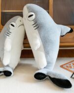 Two giant shark plushies, Fins the Chonky Shark, cuddle together on a rug.
