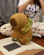 Cute Turtle Backpack Capybara plushie resting on a pink fabric surface.