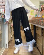 Black kawaii laced pants with bows and lace trim, casual style.