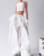 White y2k cargo pants with ruffled detailing and lace trim. A cropped top completes the look.