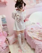 White panda print t-shirt worn by a person in a bedroom setting.