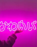 Kawaii neon light Japanese Kana Decoration 「かわいい」 displayed on a pink background.