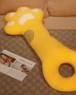 Close-up of a yellow cat paw pillow, a cute and soft sleeping pillow.