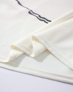 Close-up of a beige cat graphic tee, showcasing soft fabric and a playful design.