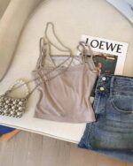 The KItty Top - Y2K Aesthetic, a light brown crop top with thin straps, styled with accessories.