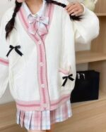 White kawaii bow sweater with plaid details and matching skirt shown on a model.