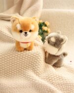 Two cute puppy collectible plush toys resting on a knitted blanket.