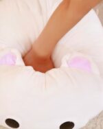 Close-up of a white Kawaii milk cat plushie with pink ears and a soft texture.
