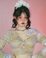 Close-up of a vintage aesthetic sweater, a hollow-out knitted long-sleeved top in pastel colors.