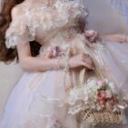 Close-up of a floral lolita dress featuring ruffles and lace details, with a basket and flowers.