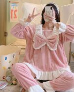 Pink kawaii flannel pajamas with lace trim and bow details, featuring a hooded top and matching pants.