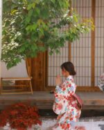 Woman wearing a retro checkered kimono in a Japanese garden setting.