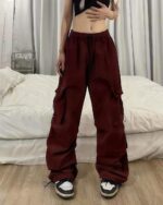 Burgundy Y2k aesthetic pants, loose fit cargo style with large pockets.