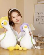 Two Kawaii Molly the Little Flower duck plushie toys, one yellow and one lilac, displayed with a person.