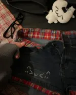 Dark denim kawaii shorts with plaid lining and doodles.