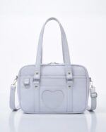 Light pink japanese schoolbag with handles and detachable strap.