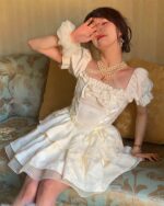 White vintage aesthetic dress with ruffled sleeves and a square neckline, detailed embroidery.