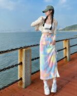 A long y2k denim skirt with a colorful tie-dye pattern, featuring adjustable drawstrings.