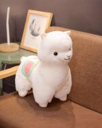 A white colorful alpaca plush toy with a pink saddle, Andean Edition.