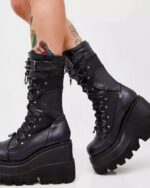 Black y2k punk boots featuring a platform sole, lacing, and buckles. Gothic style footwear.