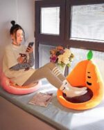 Kawaii fruit cushion displayed on a cushioned seat, featuring an orange design.