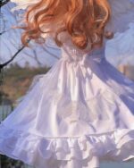 White gothic lolita dress with layers of ruffles and lace details.