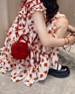 Close-up of a lolita apple dress with red apple motif and matching accessories.