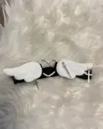 Kawaii leg accessory featuring white wings, a heart charm, and silver crosses.