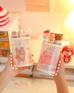 Kawaii pen holder featuring cute animal designs and colorful pens.