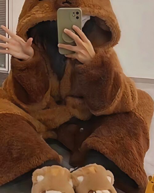 Person wearing a brown Capyvara Hooded Coat, selfie style.