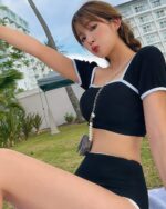 Woman wearing a black high-waisted korean aesthetic swimsuit on a sunny day.