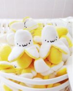 Several kawaii chibi banana plushies in a basket, perfect as a keychain.