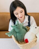 Spooky cute spider plush in a woven basket with other plush toys.