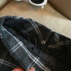 Close-up of a plaid mini skirt with a preppy aesthetic, featuring a zipper detail.