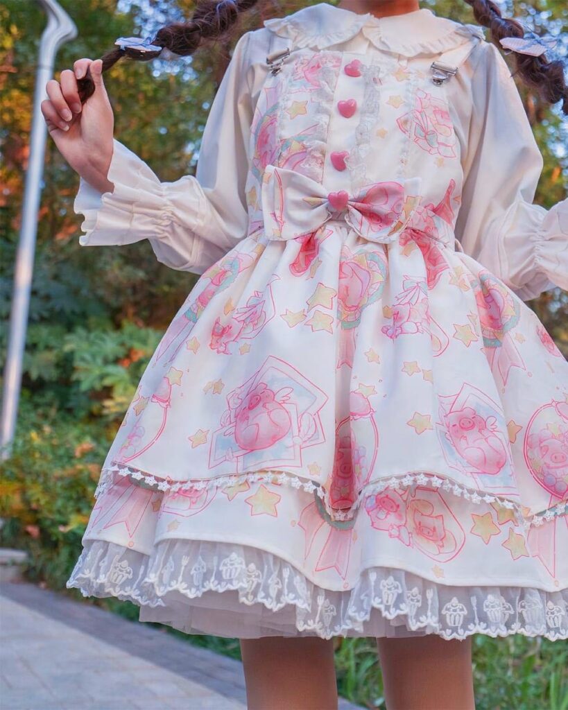 Close-up of an angel kawaii dress with pink and white Lolita aesthetic, featuring star and pig motifs.
